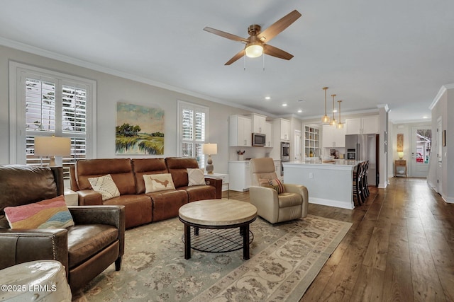 living area with hardwood / wood-style floors, crown molding, and a wealth of natural light