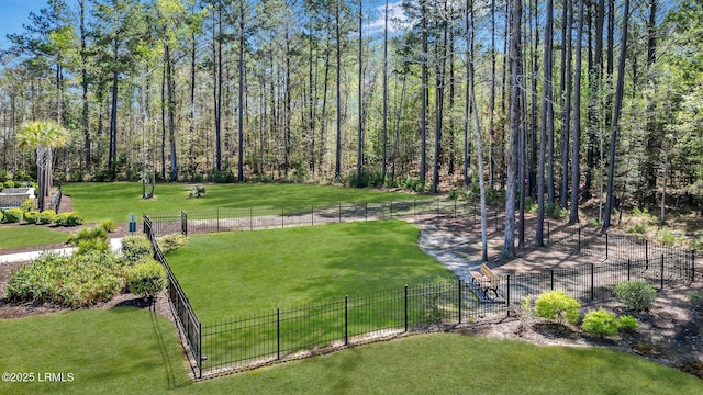 view of community featuring a yard and fence