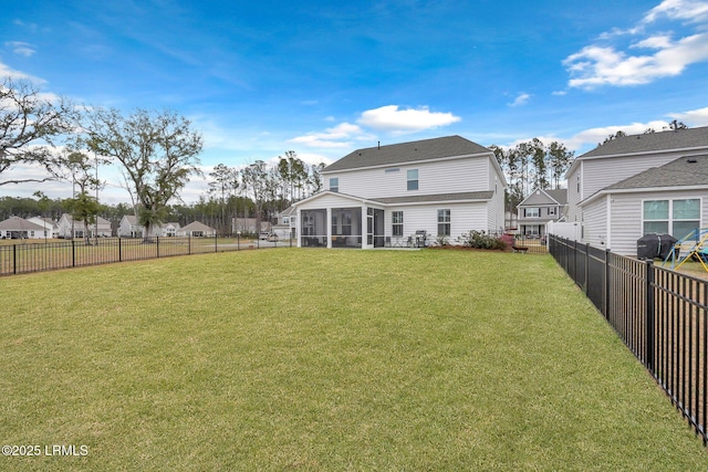 rear view of property featuring a sunroom, a fenced backyard, and a yard