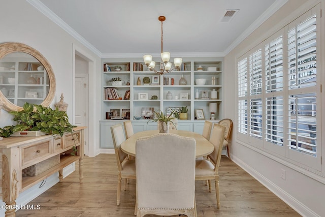 dining space featuring light wood finished floors, visible vents, a chandelier, and crown molding