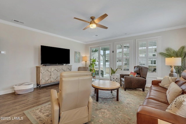 living area featuring ornamental molding, visible vents, ceiling fan, and wood finished floors