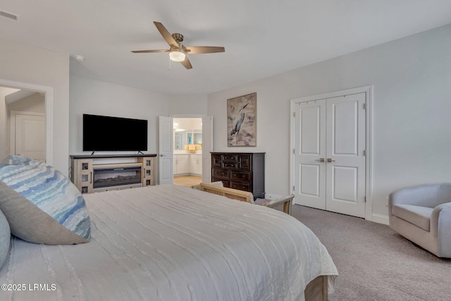 carpeted bedroom featuring a closet, visible vents, a ceiling fan, connected bathroom, and baseboards