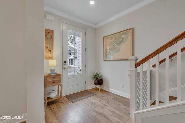 foyer entrance featuring baseboards, stairs, ornamental molding, and wood finished floors