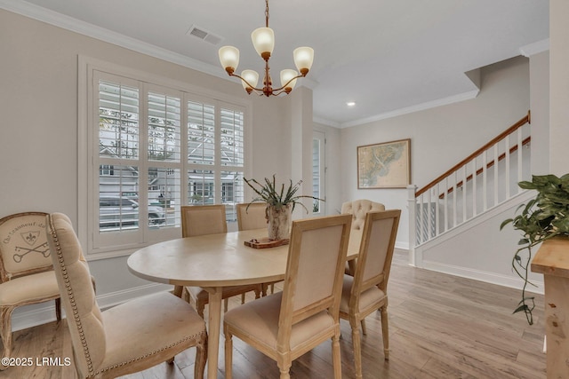 dining space with light wood-style flooring, stairs, visible vents, and ornamental molding