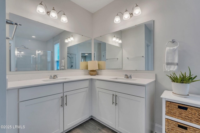 bathroom with double vanity, a stall shower, and a sink