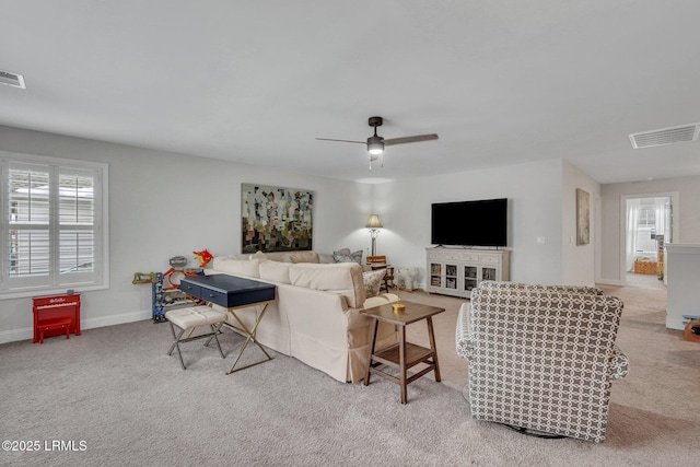 living room featuring ceiling fan, carpet, visible vents, and baseboards