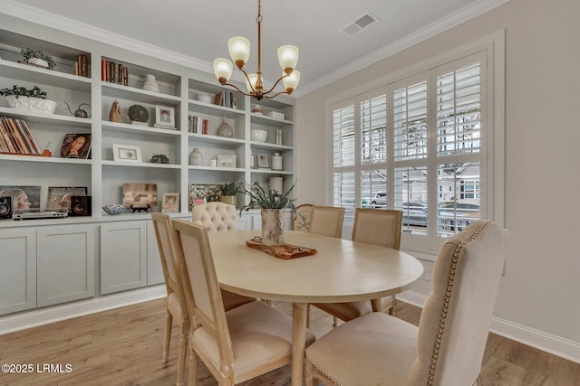 dining room with light wood finished floors, plenty of natural light, visible vents, and ornamental molding