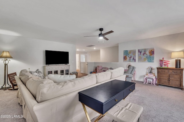 living area with a ceiling fan, visible vents, and carpet flooring