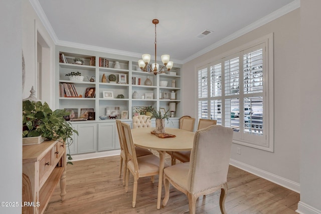 dining space featuring baseboards, visible vents, ornamental molding, light wood-type flooring, and a chandelier