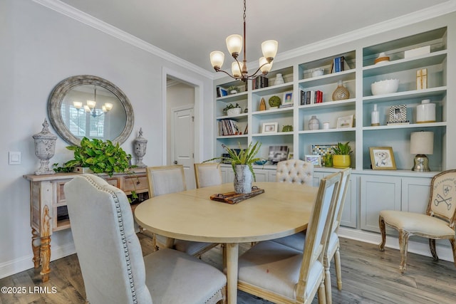 dining space with crown molding, a chandelier, and wood finished floors