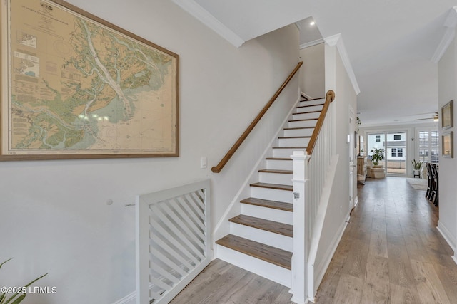 stairs featuring baseboards, ornamental molding, and wood finished floors