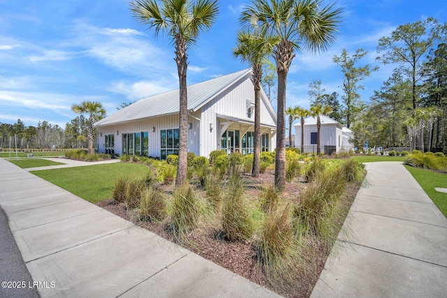 view of front of property with metal roof and a front lawn