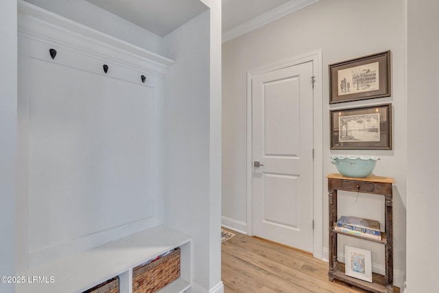 mudroom with crown molding, light wood-style flooring, and baseboards