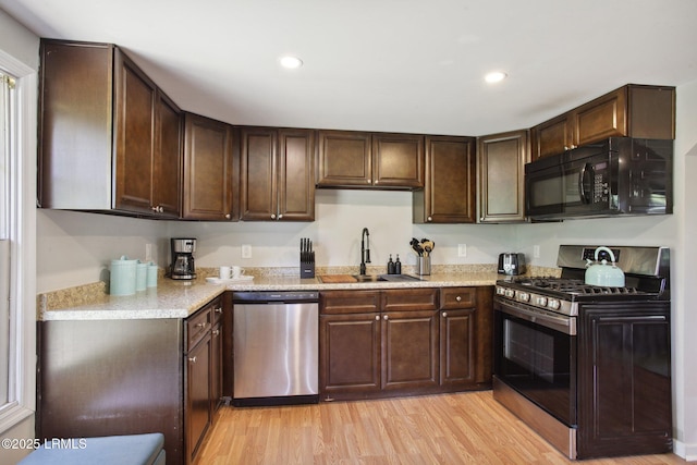 2503 Twin Oaks Ln, Port Royal, SC 29935 - kitchen featuring stainless steel appliances, a sink, dark brown cabinets, light wood finished floors, and recessed lighting