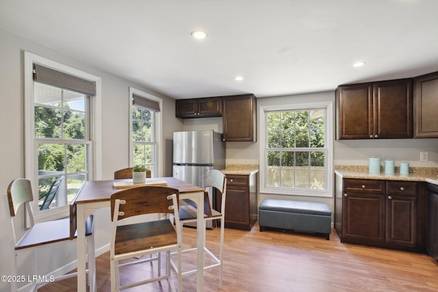 2503 Twin Oaks Ln, Port Royal, SC 29935 - kitchen featuring dark brown cabinets, light wood finished floors, recessed lighting, and light stone countertops