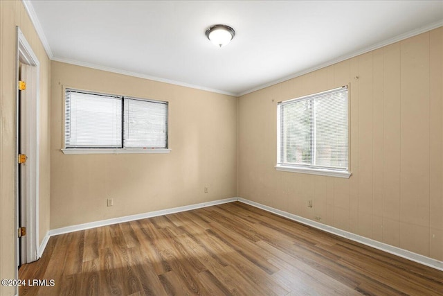 spare room with wood-type flooring and ornamental molding