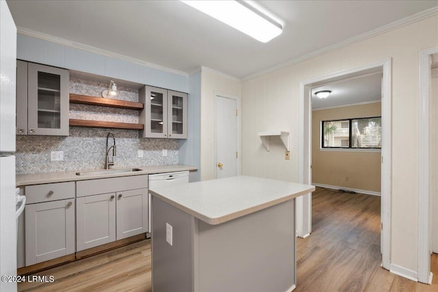 kitchen featuring sink, gray cabinets, ornamental molding, light hardwood / wood-style floors, and a kitchen island