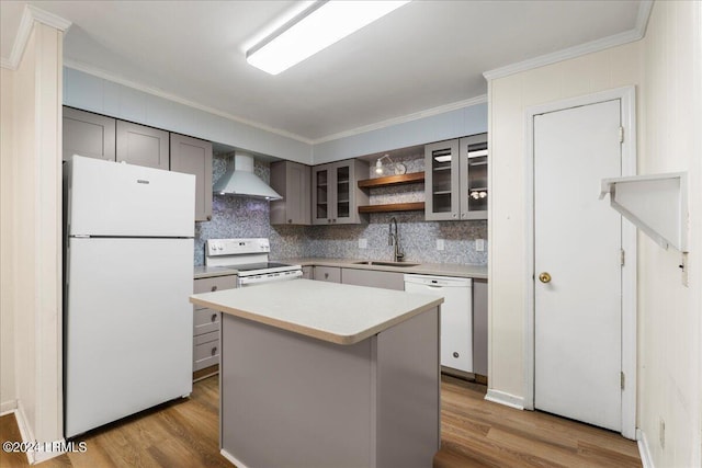 kitchen featuring a kitchen island, sink, crown molding, white appliances, and wall chimney exhaust hood