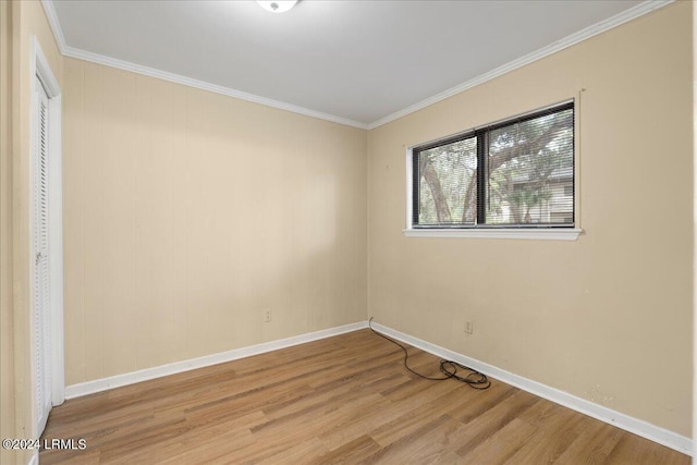 spare room with crown molding and light hardwood / wood-style flooring