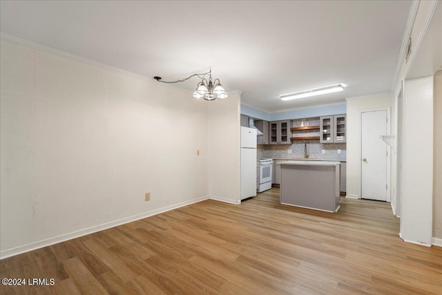 kitchen with white appliances, backsplash, light hardwood / wood-style floors, a kitchen island, and a chandelier