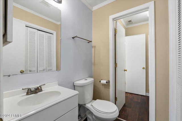 bathroom with vanity, crown molding, wood-type flooring, and toilet