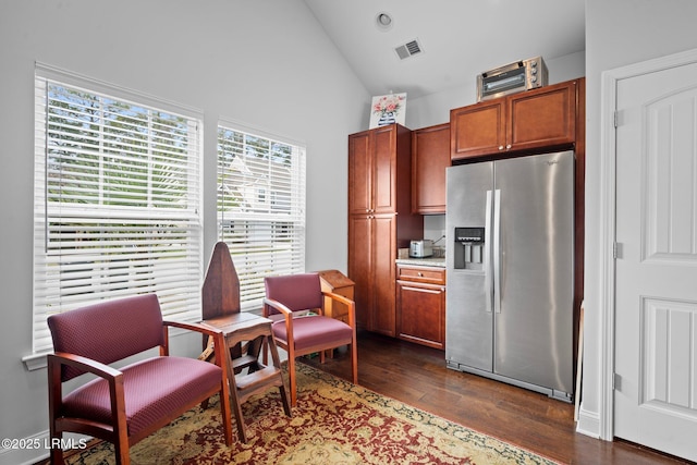 sitting room with dark wood-style floors, visible vents, and high vaulted ceiling