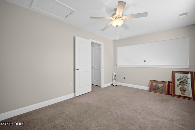 carpeted spare room featuring attic access, visible vents, ceiling fan, and baseboards