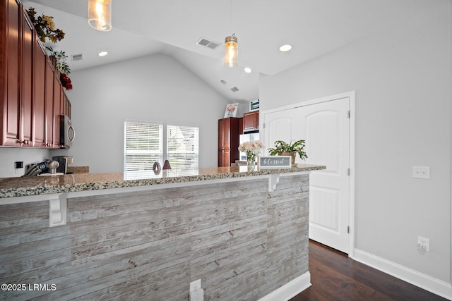 kitchen featuring a peninsula, visible vents, pendant lighting, and stainless steel microwave