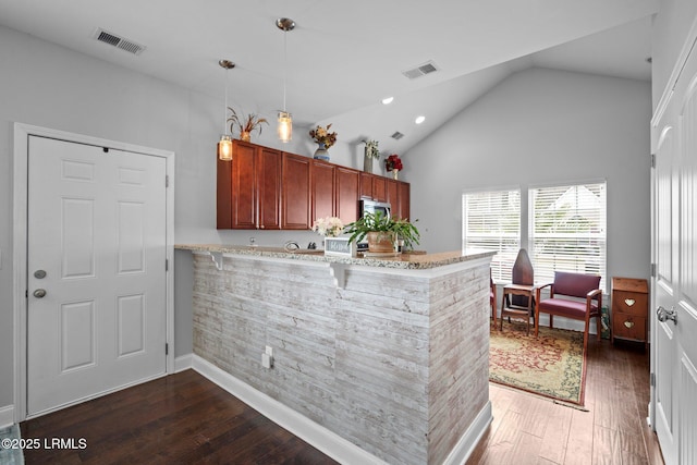 kitchen featuring a peninsula, dark wood-style flooring, visible vents, and decorative light fixtures