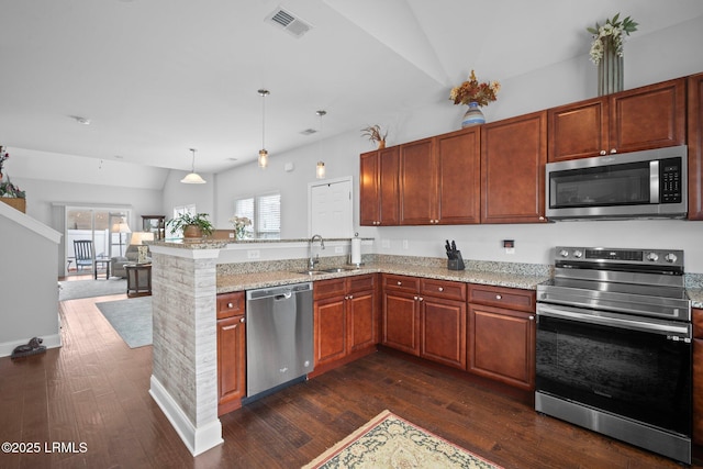 kitchen featuring a peninsula, appliances with stainless steel finishes, pendant lighting, and a sink