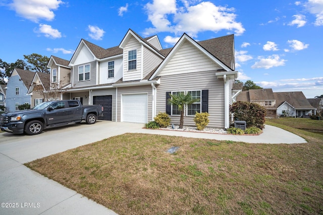 view of front of property featuring a front lawn, a residential view, driveway, and an attached garage