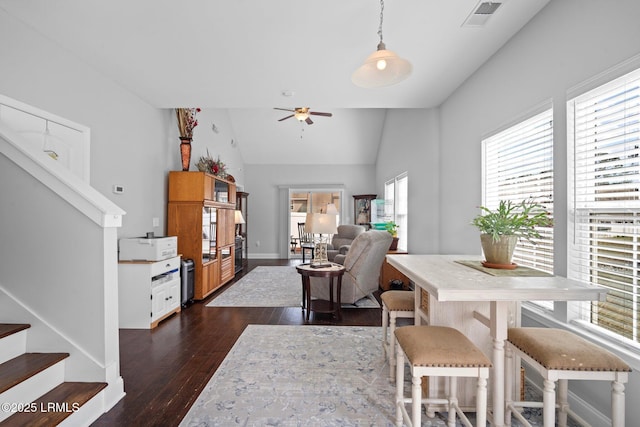 dining area featuring visible vents, lofted ceiling, ceiling fan, dark wood-type flooring, and stairs