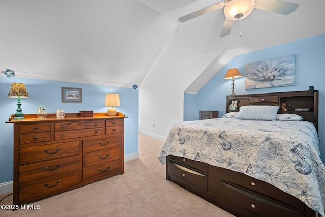 bedroom featuring a ceiling fan, light colored carpet, vaulted ceiling, and baseboards