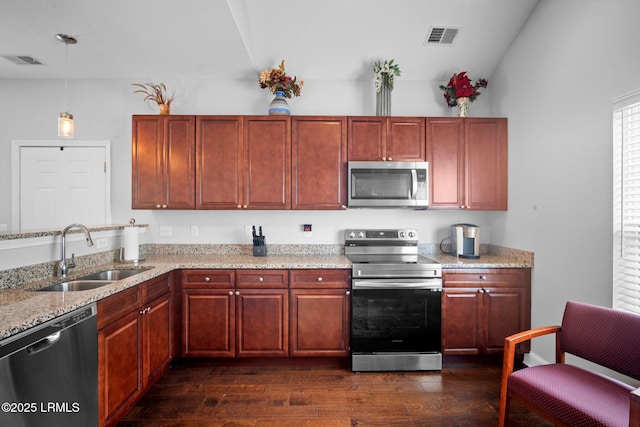 kitchen featuring visible vents, appliances with stainless steel finishes, pendant lighting, and a sink