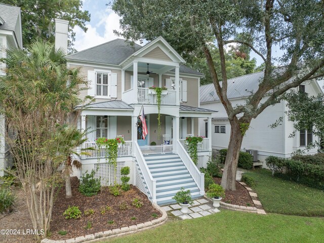 view of front of home featuring ceiling fan, a porch, a front lawn, and central air condition unit