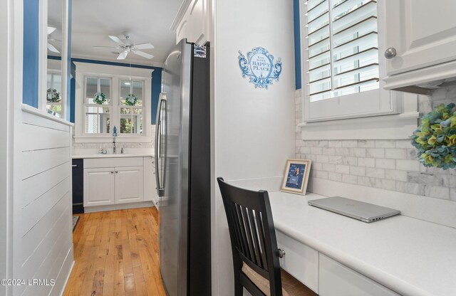 kitchen featuring tasteful backsplash, a wealth of natural light, stainless steel fridge, and white cabinets