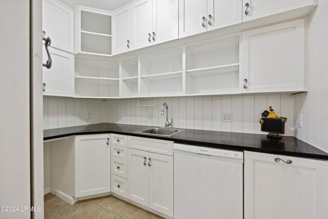 kitchen featuring light tile patterned flooring, sink, white dishwasher, decorative backsplash, and white cabinets