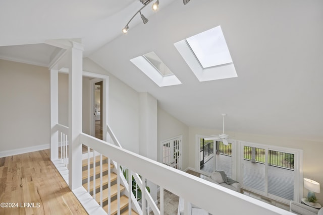 corridor with lofted ceiling and light hardwood / wood-style flooring