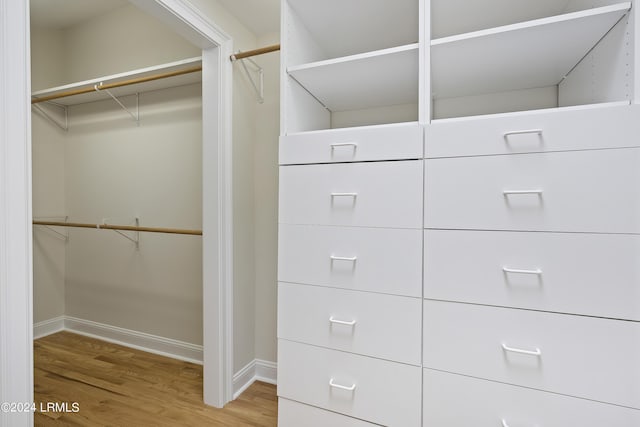 walk in closet with hardwood / wood-style flooring