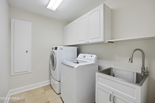 clothes washing area with sink, cabinets, washer and dryer, and light tile patterned flooring