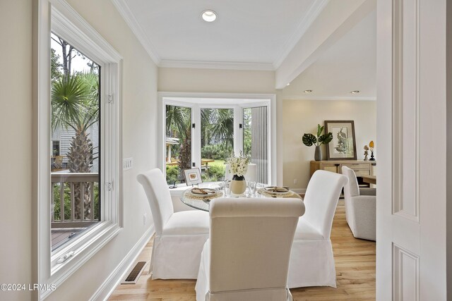 dining room with crown molding and light hardwood / wood-style floors