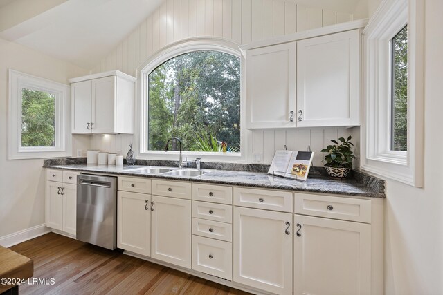 kitchen with light wood-type flooring, stainless steel dishwasher, sink, and white cabinets