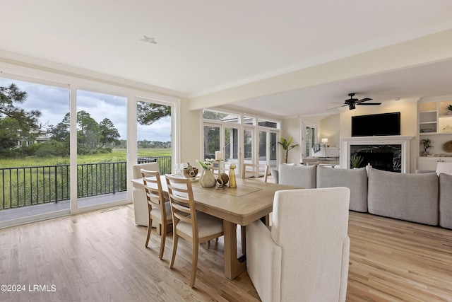 sunroom with ceiling fan and a high end fireplace