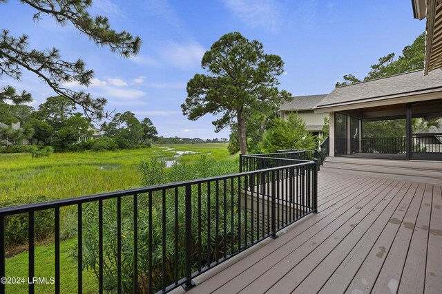 wooden deck featuring a water view and a sunroom