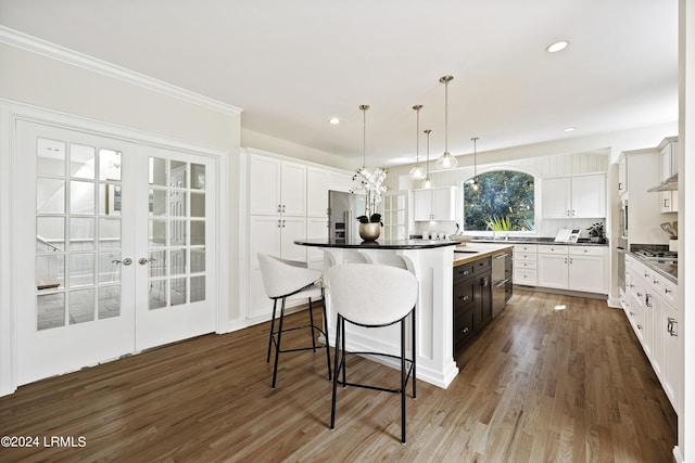 kitchen with a kitchen island, pendant lighting, tasteful backsplash, white cabinetry, and dark hardwood / wood-style flooring