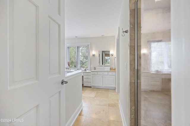 bathroom featuring tile patterned floors, a shower with shower door, and vanity