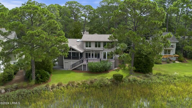 back of property with a yard and a sunroom