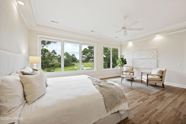 bedroom with crown molding, hardwood / wood-style flooring, and ceiling fan