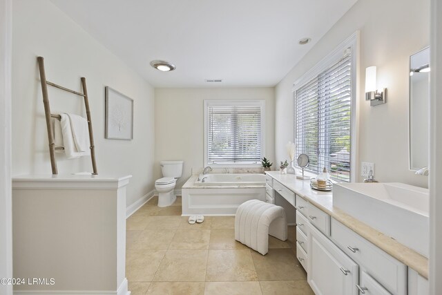 bathroom featuring vanity, toilet, tile patterned flooring, and a tub