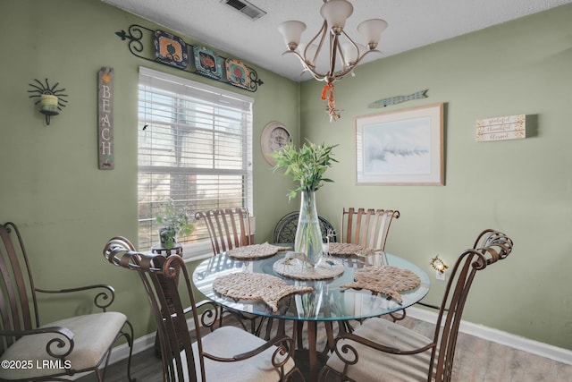 dining room featuring hardwood / wood-style flooring and a chandelier